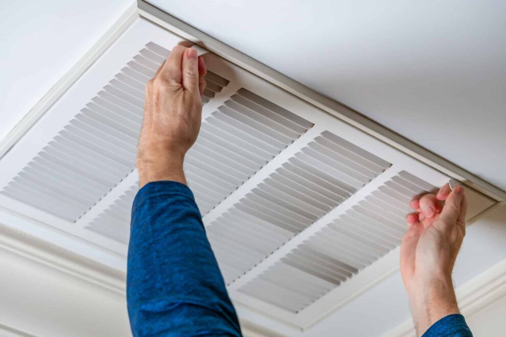 man opening ceiling air vent