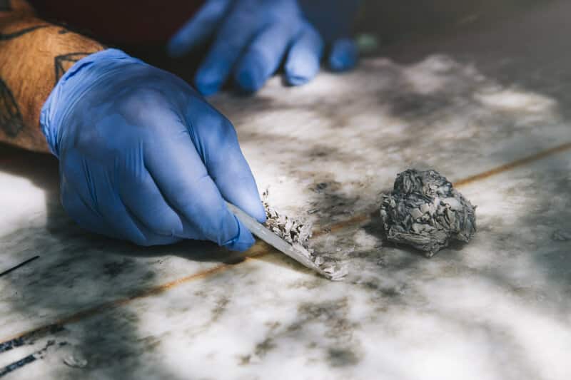 Closeup of gloved hands removing old wax with a wax comb. asbestos removal