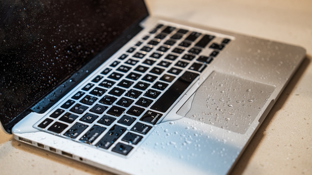 Close-up,Of,A,Wet,Laptop,Keyboard,With,Water,Droplets. Laptop with water damage